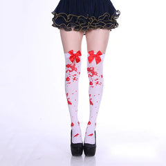 White over-knee socks with red splatter print and red cuff bows, styled with black shoes