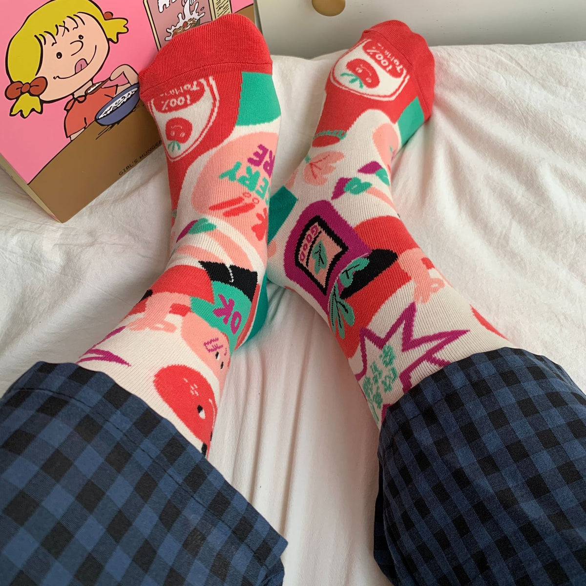 Cherry Tomato crew socks worn with checked trousers, showing red toes and colorful grocery illustrations