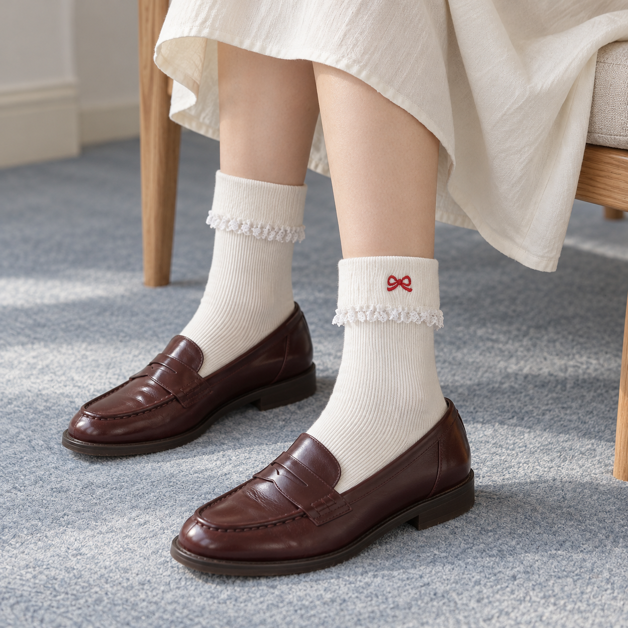 AI styling illustration of White fold-over ribbed socks with tiny red embroidered bow detail, lace edging and dark brown loafers in a high-oblique seated outfit