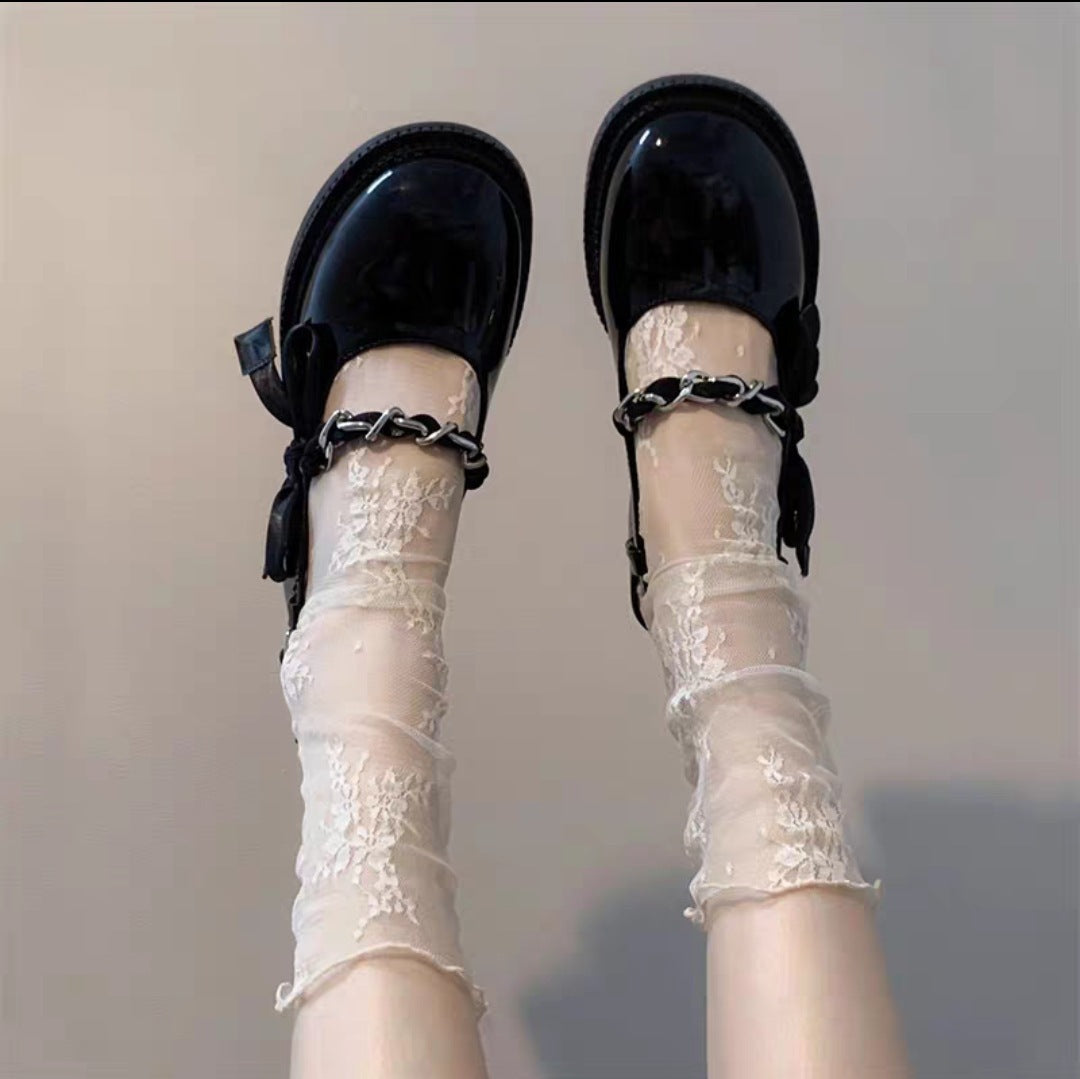 Untouched supplier reference of White sheer net socks with small floral-and-vine sprigs and narrow rolled rims; shoes conceal unverified foot construction
