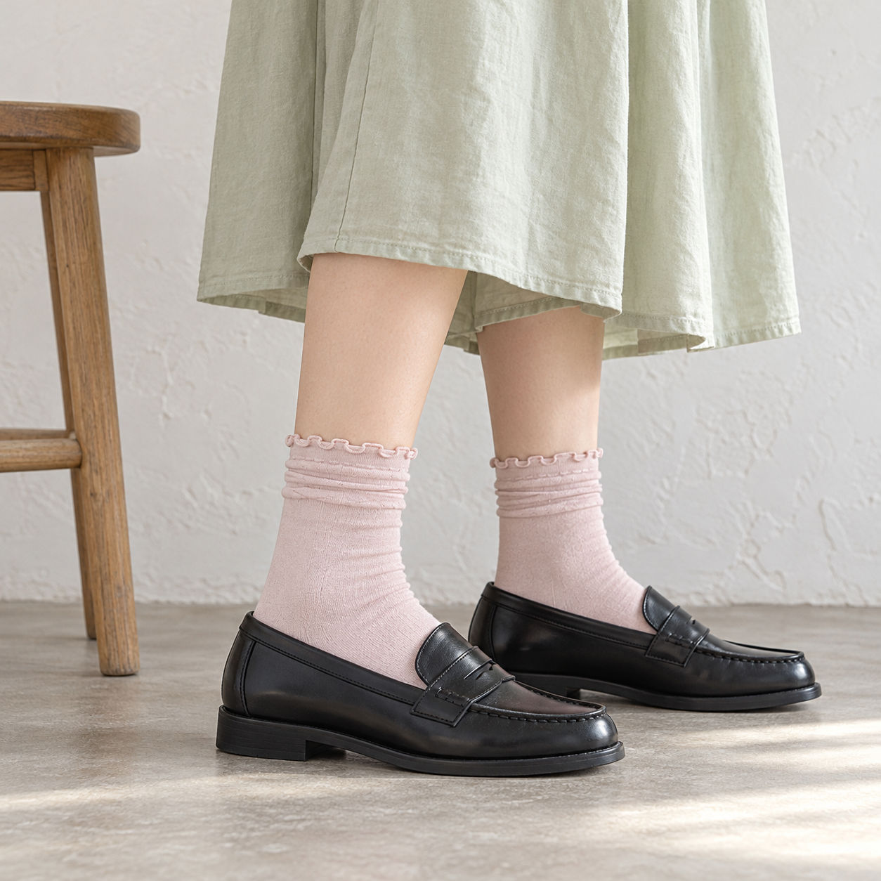 AI side outfit illustration of Light Pink fine-knit-looking socks with softly rolled upper styling, a pale green skirt and black loafers