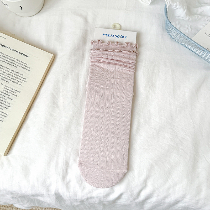 Untouched supplier reference of Light Pink fine-knit-looking sock with small waved rim, softly gathered upper rolls and plain rounded front toe; paper card is a prop