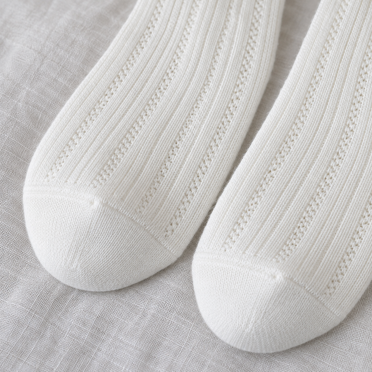 AI close product illustration of fine vertical openwork columns meeting the smooth White toe panels