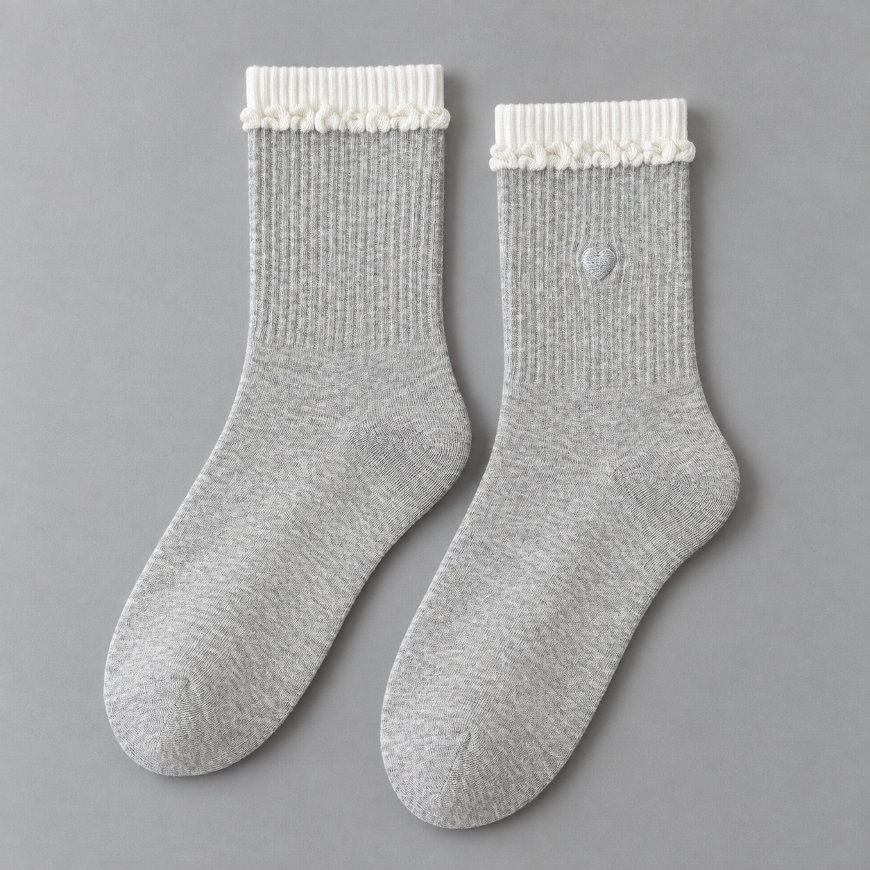 AI product illustration of a matching Light Gray pair with white upper bands, curled white knit trim and a small gray embroidered heart.
