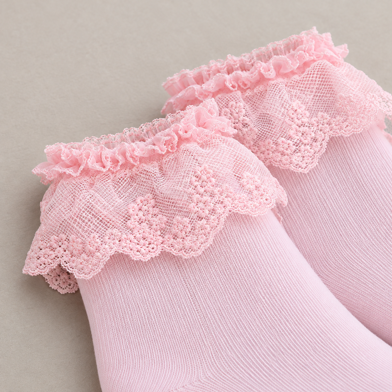 AI close product illustration of the small Pink top ruffle and downward scalloped floral lace flounce over fine knit.