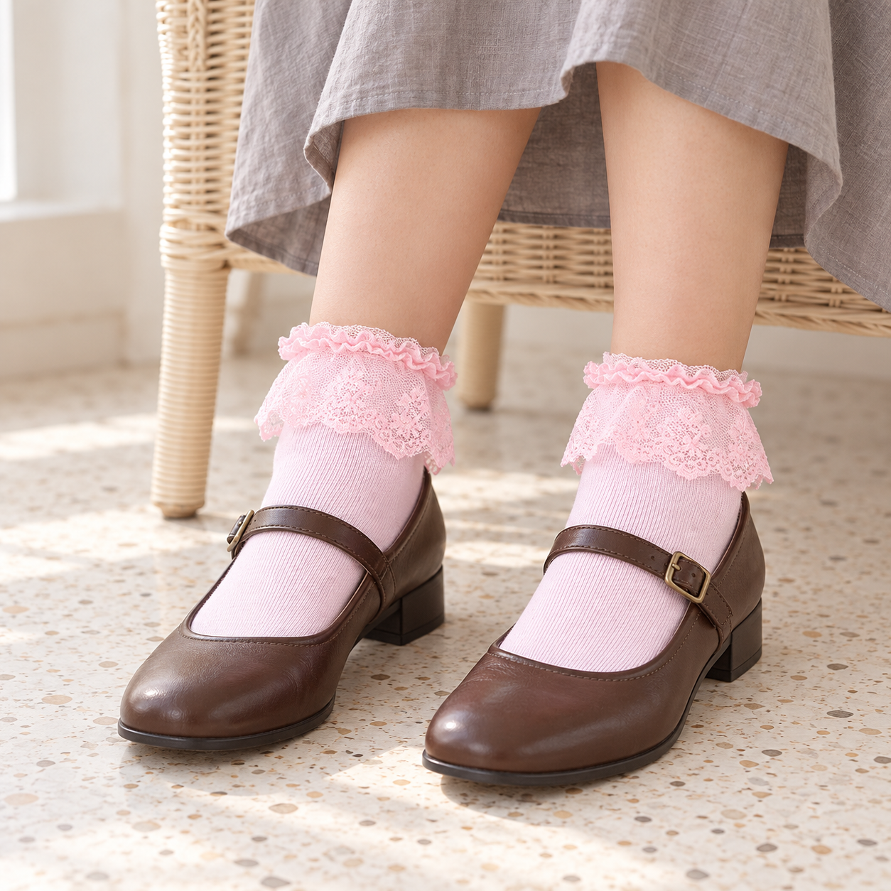 AI seated styling illustration of Pink floral lace-flounce ankle socks with brown Mary Janes and a gray skirt beside a wicker chair.
