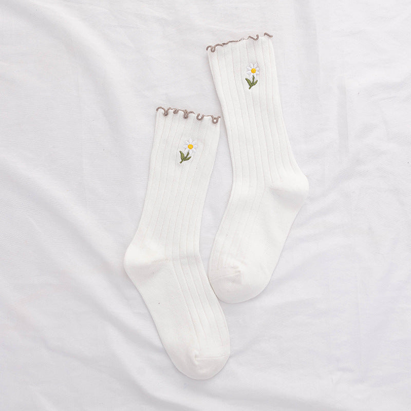 Untouched original reference showing a White matching ribbed pair with narrow brown wavy top edges and a small stemmed daisy on each outer shaft.