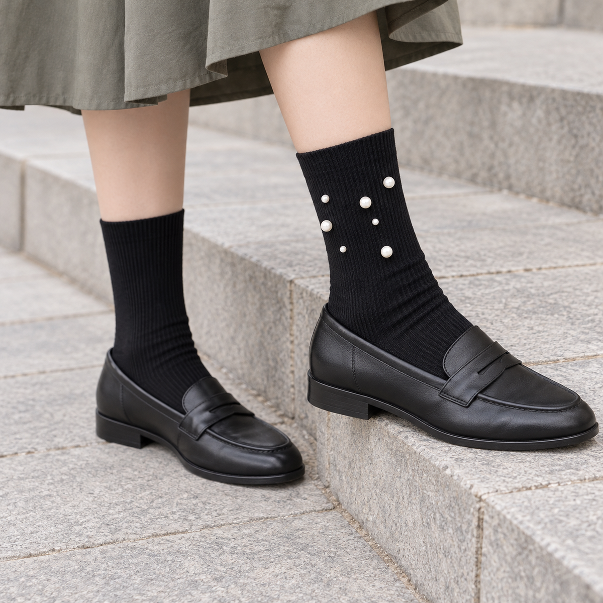 AI styling illustration of Black fine-rib socks with a seven-bead outer cluster, worn with charcoal loafers on gray stone steps.