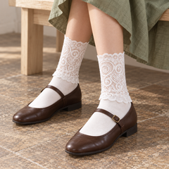 AI seated outfit illustration of White scroll-lace socks with dark brown Mary Janes and a muted green skirt.