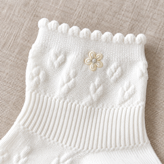 AI close detail illustration of the small daisy, rounded scalloped opening and raised upper texture of the White socks.