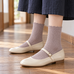 AI side styling illustration of Heather Taupe fine-rib socks with cream Mary Jane shoes and a navy skirt on a wooden floor.