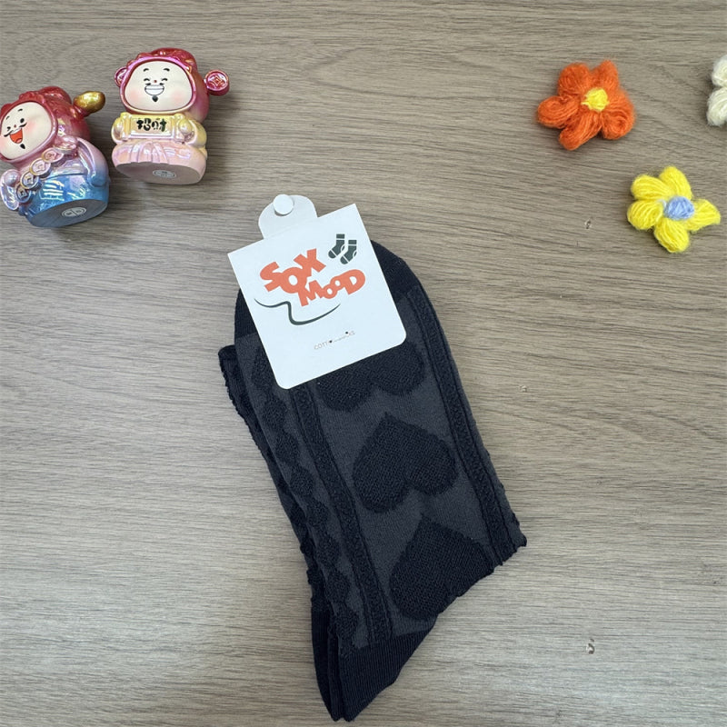 Untouched original reference showing Black raised-heart knit socks with cable columns and original packaging.