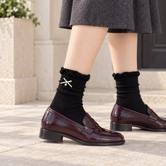 AI side styling illustration of Black bow and pearl-style drop socks with oxblood loafers on a stone porch.