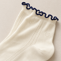 AI detail illustration of a Cream sock opening with thin navy wavy edging and subtle heart pointelle.