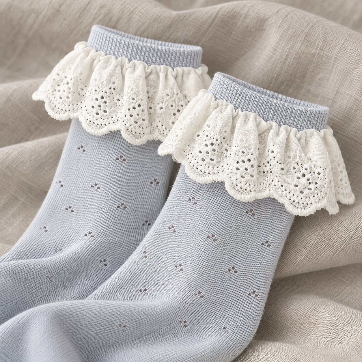 AI product detail illustration of Light Blue sock shafts and White embroidered scalloped flounces on gray linen.