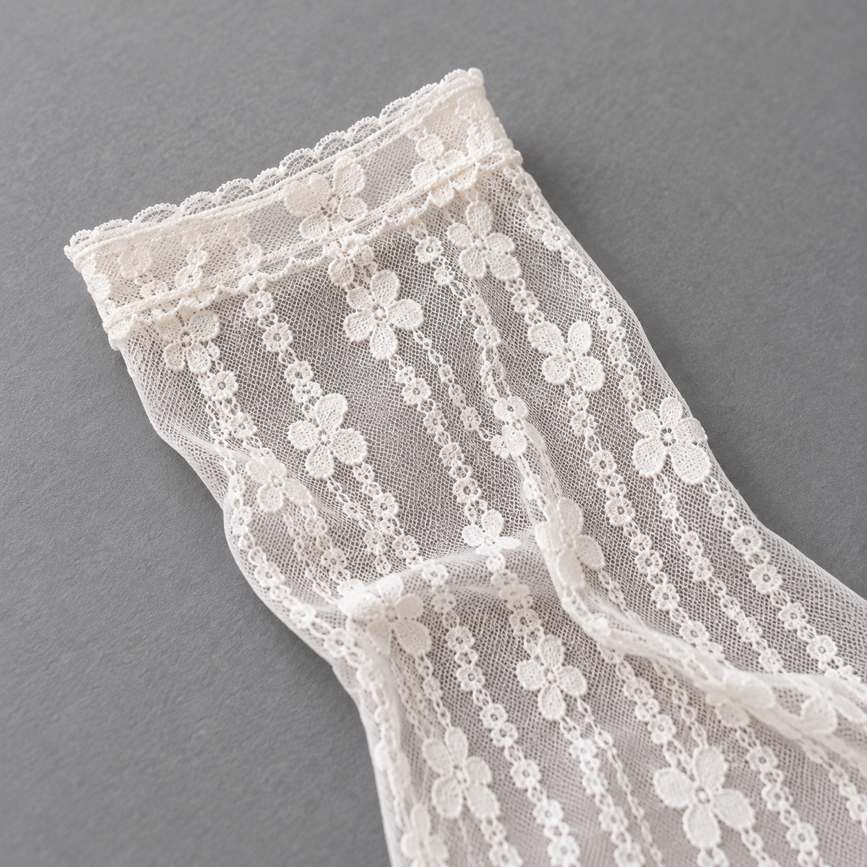 AI editorial illustration of Narrow cuff and vertical flower-chain mesh of an empty White sock on gray paper.