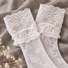 AI product illustration of empty White scroll-lace sock cuffs and fine floral mesh on linen.