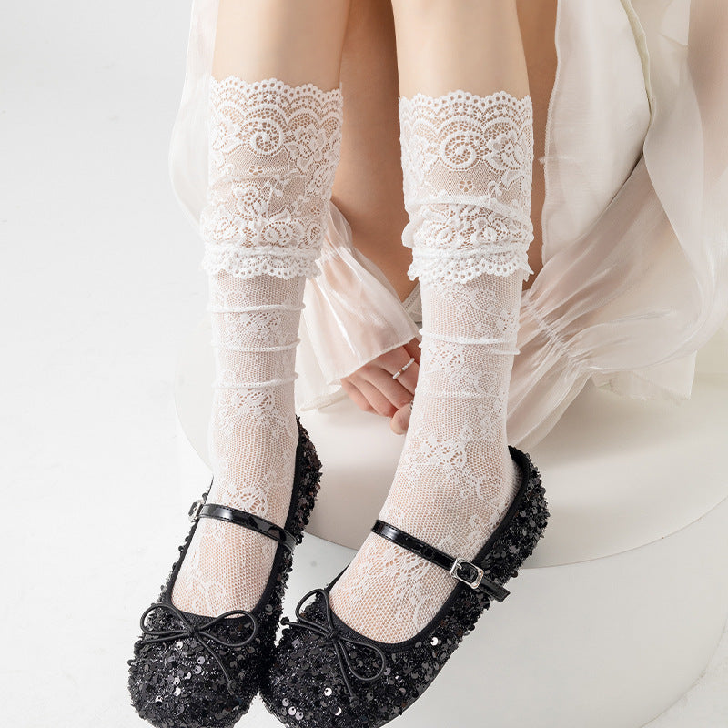 Untouched original reference of White floral mesh socks with broad scroll-lace cuffs, worn with black Mary Janes.