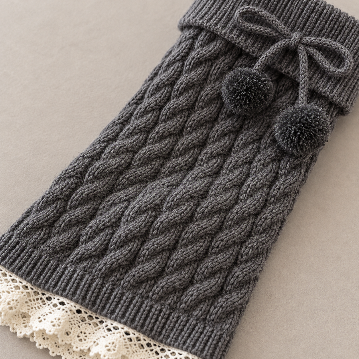 AI angled product illustration showing continuous cable-knit columns between a Dark Gray folded cuff and cream lower lace.