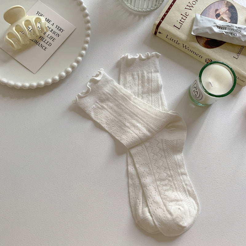 White socks with vertical leaf-like openwork and lightly ruffled cuffs, displayed as a pair