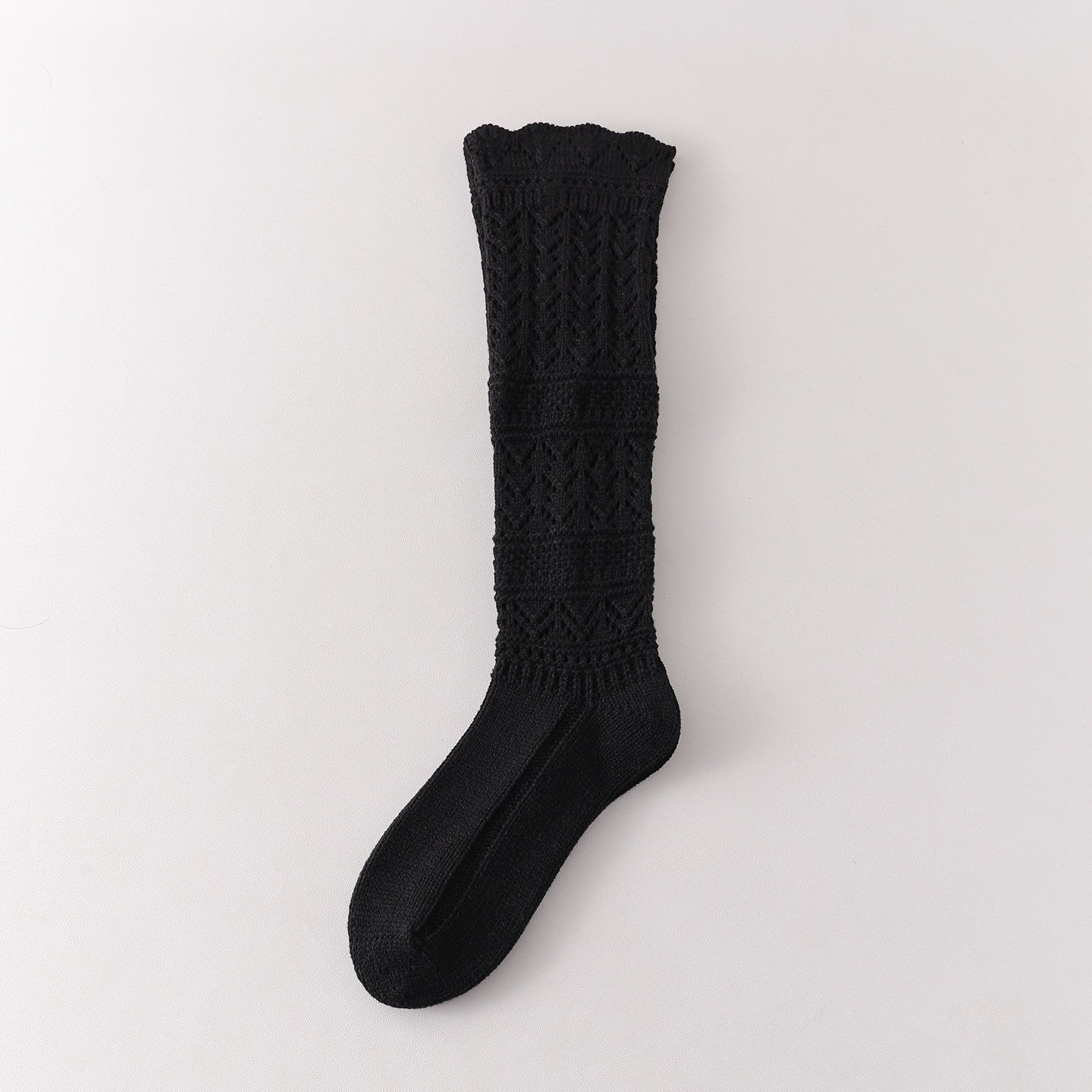 Black long sock with repeated leaf pointelle sections and two broad horizontal textured bands