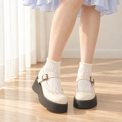 AI styling illustration of Milk White cable ankle socks with curled cuffs, a pale blue skirt and cream platform Mary Janes.