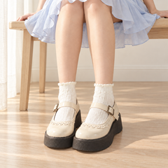 AI styling illustration of a seated adult wearing Milk White short cable socks and cream Mary Janes beneath a pale blue skirt.