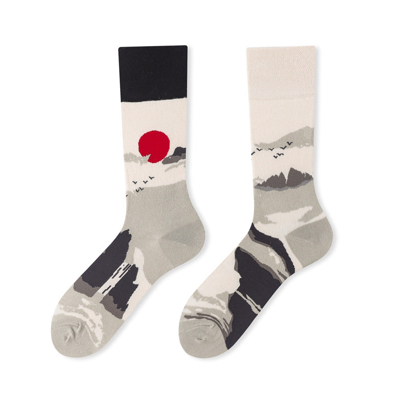 Mismatched cream and gray crew sock pair with mountain landscapes, a red sun and different cuffs