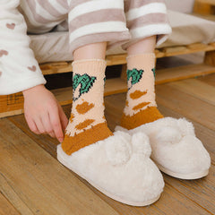 Orange Broccoli fuzzy crew socks worn with striped pajamas and white slippers, shown for styling