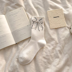 White crew socks with dark-edged bows and small decorative dot accents