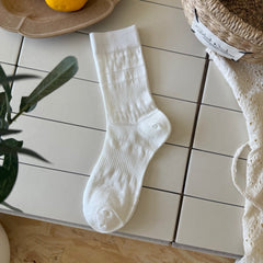 Natural White ribbed sock with straight cuff and horizontal bands of small round eyelets