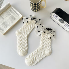 White chevron-textured socks with sheer black-dotted bows at the cuffs