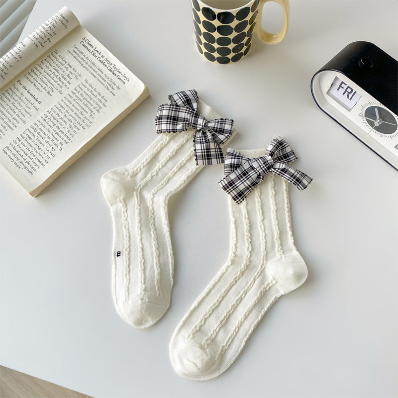 White openwork socks with black-and-white plaid bows at the cuffs