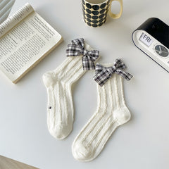 White openwork socks with black-and-white plaid bows at the cuffs