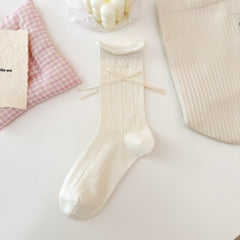 Cream Heart pattern crew sock with rows of knitted hearts, a rolled cuff, round button and long ribbon bow.