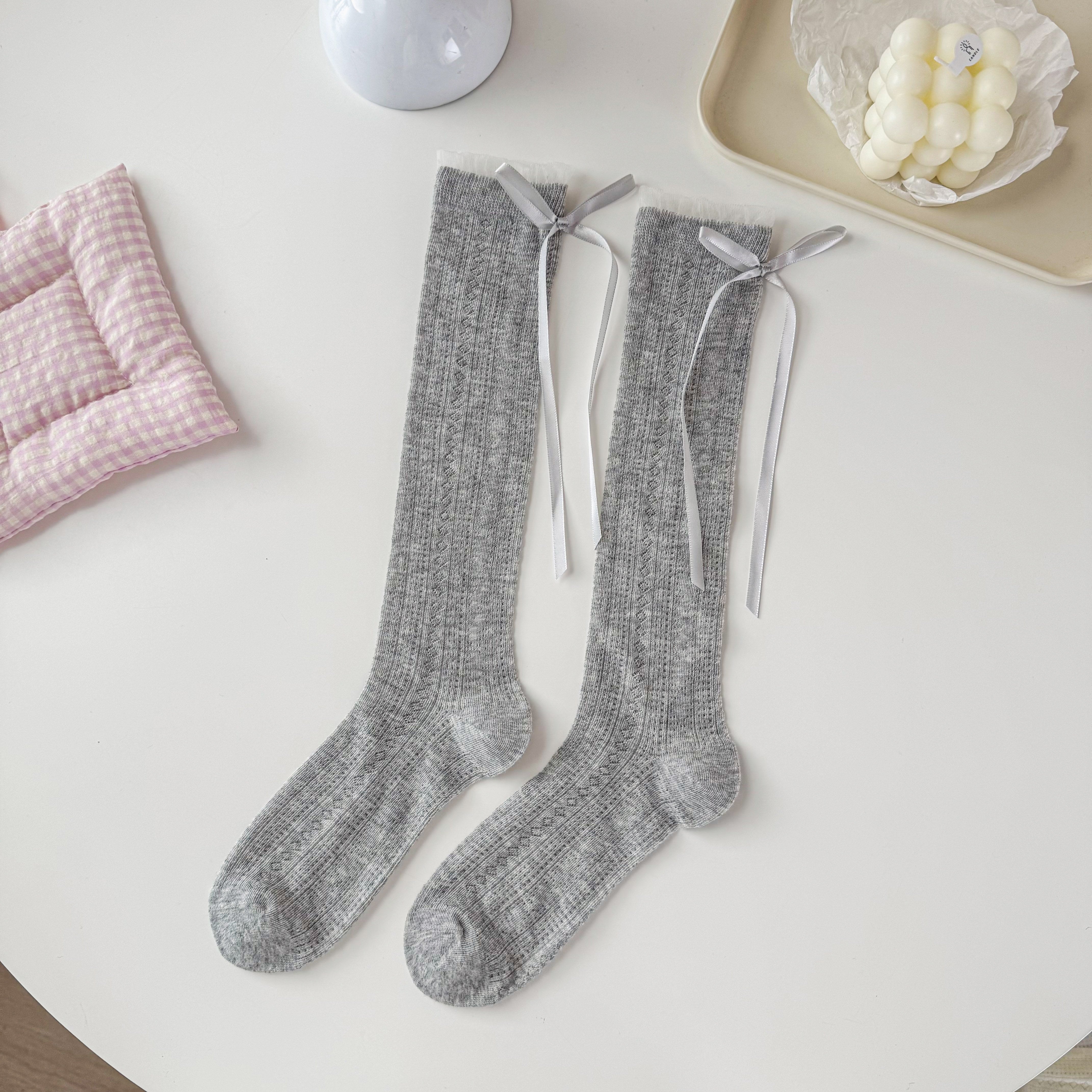Gray pointelle crew socks with narrow cuff edging and long gray ribbon tails