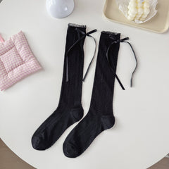 Black pointelle crew socks with a narrow sheer cuff rim and long black ribbon bows