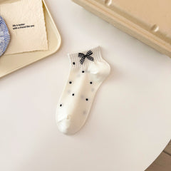 Black Dot style ivory ankle sock with sparse black dots, a ribbed cuff and gingham bow.