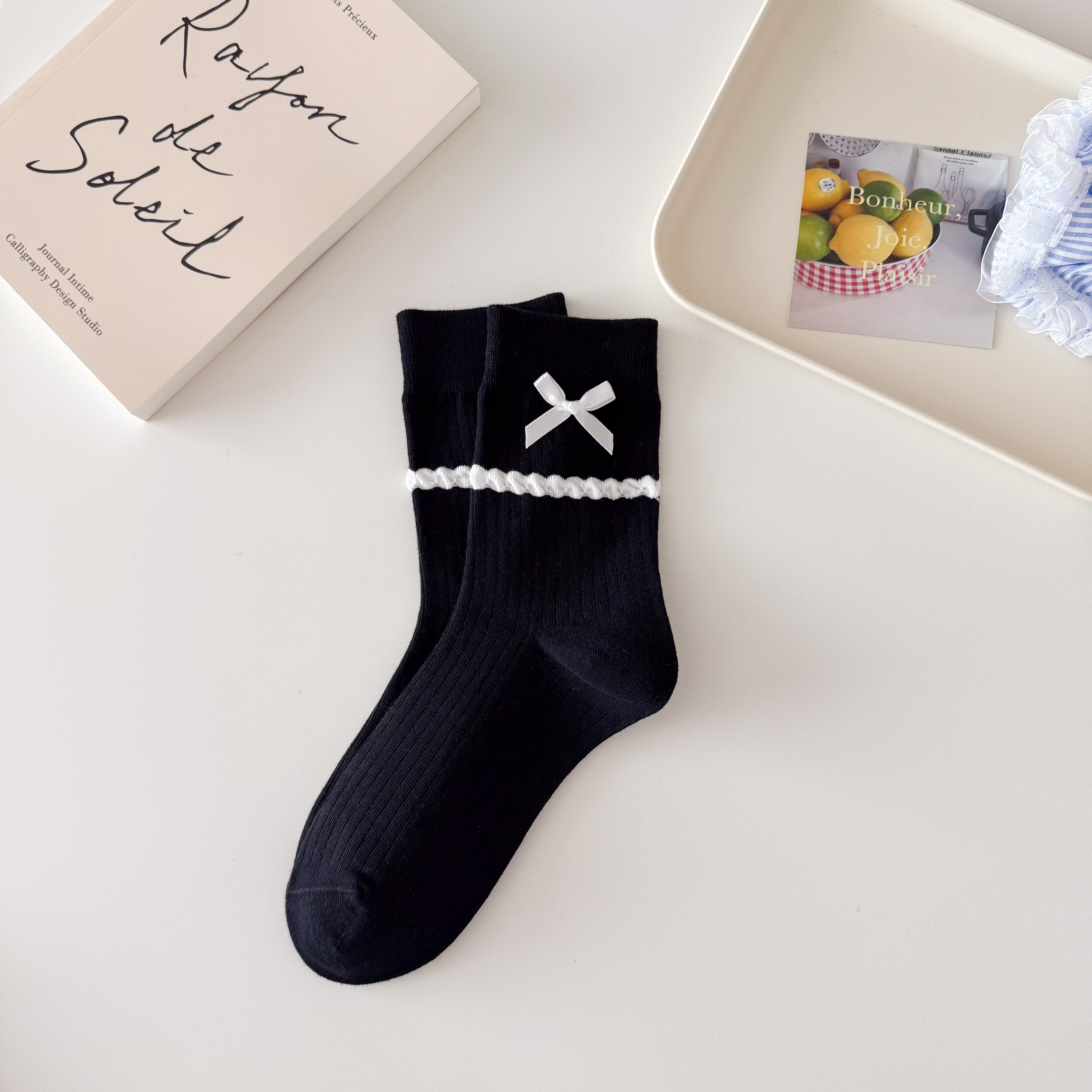 Black ribbed crew socks with straight cuffs, white ribbon bows and raised white dot knit bands.