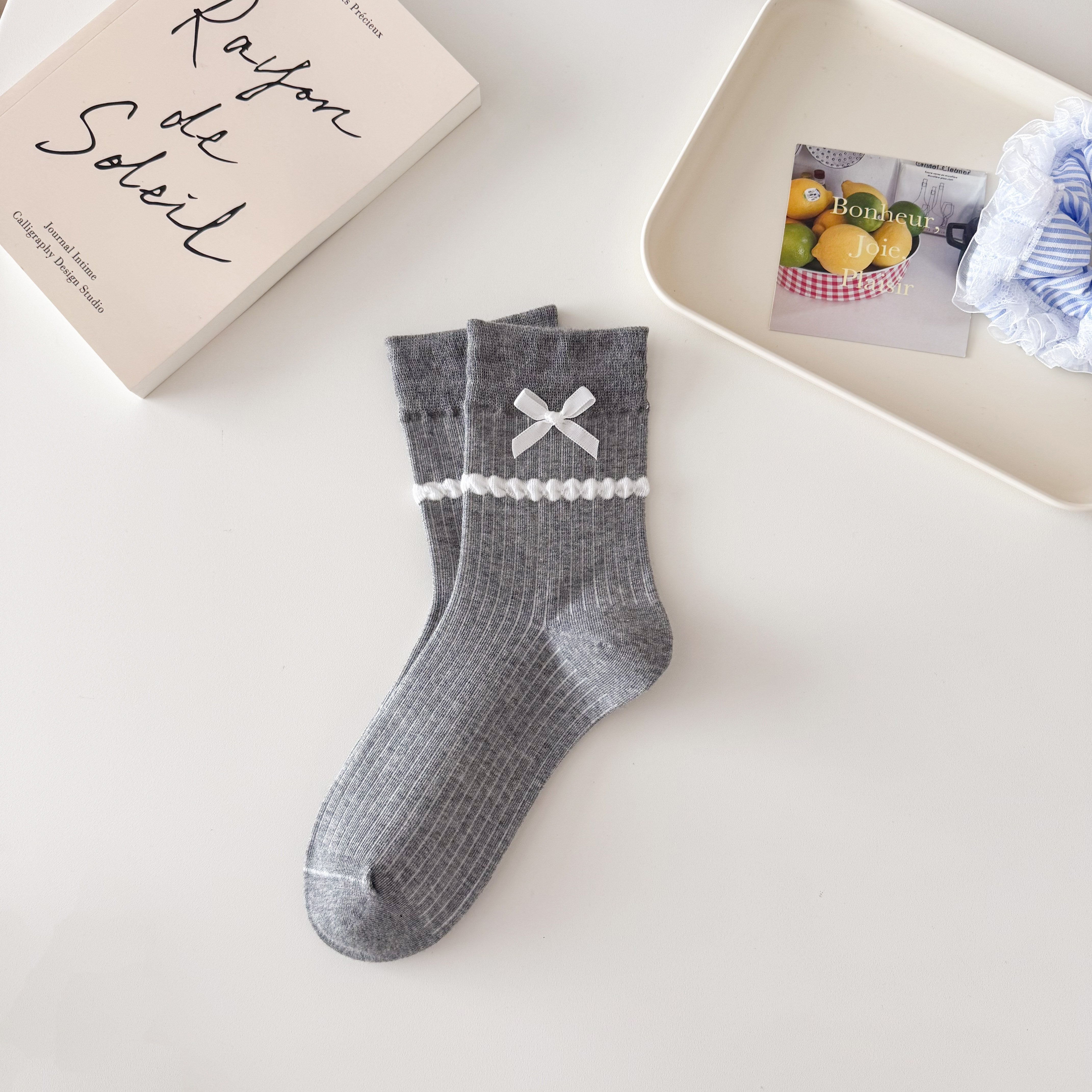Gray ribbed crew socks with straight cuffs, white ribbon bows and raised white dot knit bands.