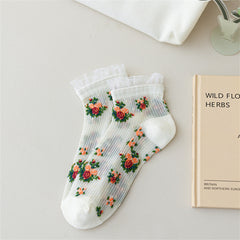 White sheer ankle socks with colorful rose bouquets, white toes and heels, and lightly frilled cuffs