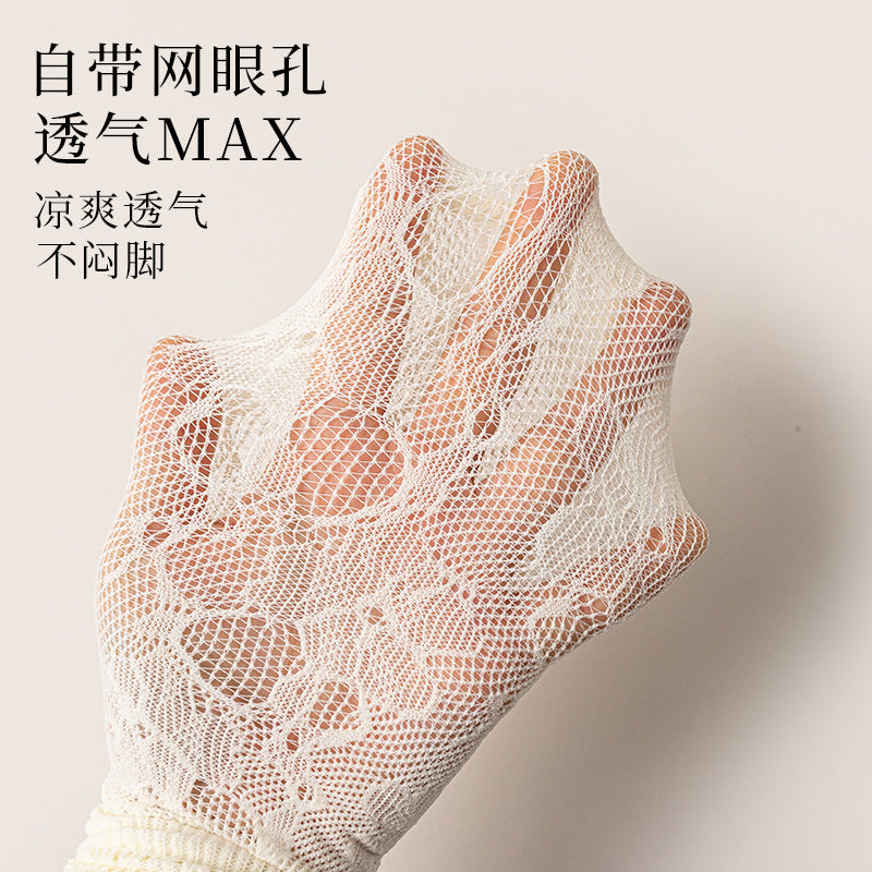 Close view of pale rose-and-leaf lace over a hand, showing the open mesh structure