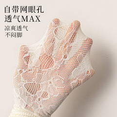 Close view of pale rose-and-leaf lace over a hand, showing the open mesh structure