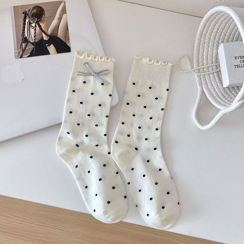 White dotted socks with frilled cuffs and a gray bow shown on one sock
