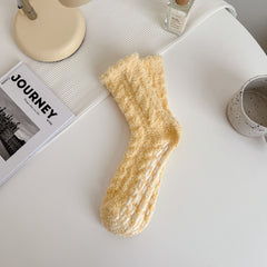 Custard textured crew socks with scalloped cuffs and white bars on the soles