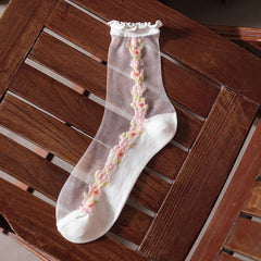 Sheer crew sock with a white sole, ruffled cuff and pink flower chain