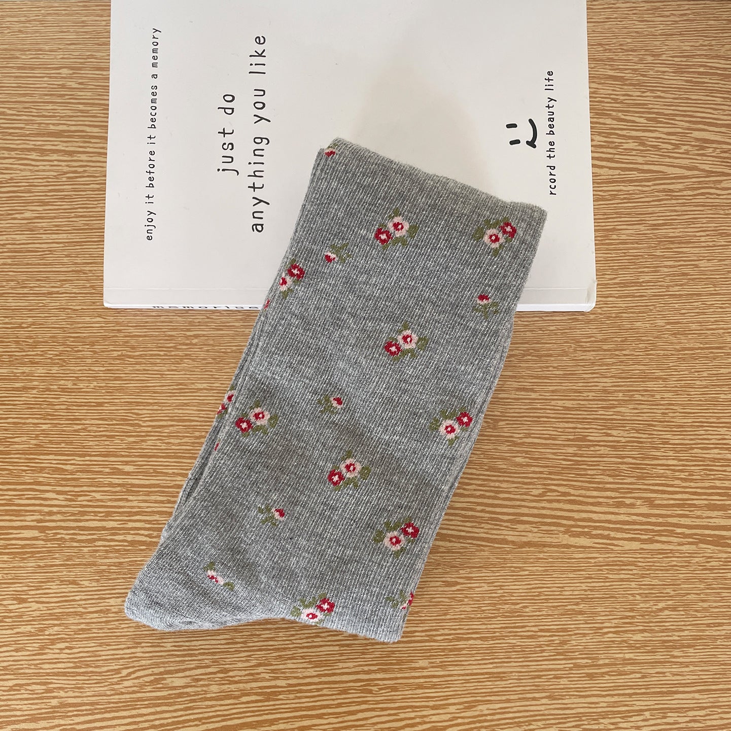 Gray calf sock with tiny flower clusters across a fine ribbed body